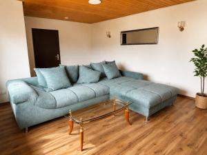 a living room with a blue couch and a mirror at Ferienwohnung Maison Maurus nahe Idar-Oberstein in Mörschied