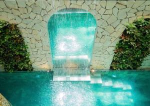 a swimming pool with a water fountain in a building at Amsphere Homestay & Restaurant in Hanoi