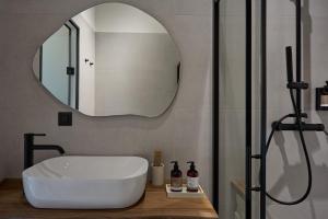 a bathroom with a white sink and a mirror at Oikia Pouloudi in Kimolos