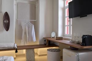 a room with a counter with a coat hanging on a wall at Oikia Pouloudi in Kimolos +22 photos