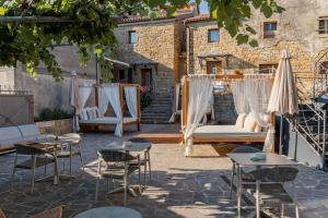 a patio with chairs and tables and umbrellas at Istrian Perfect Life in Šmarje