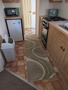 a kitchen with a trash can in the floor at Caravan 68 The Vale in Fishguard