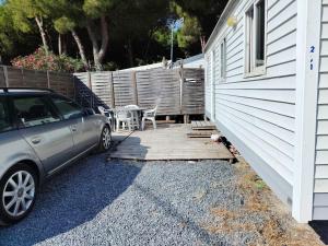 a car parked next to a house with a wooden deck at Camping Les Embruns N2 in Le Grau-dʼAgde +4 photos