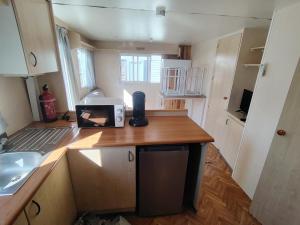 a kitchen with a wooden counter top with a sink at Camping Les Embruns N2 in Le Grau-dʼAgde