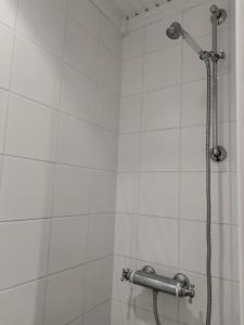 a shower in a white tiled bathroom at Et soverom, delt bad in Fredrikstad +24 photos