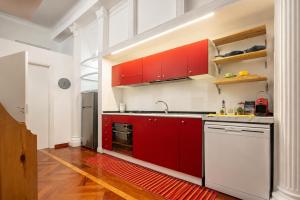 a kitchen with red cabinets and a white dishwasher at Il gioiellino in Agropoli