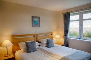 a bedroom with two beds and a window at Links Apartment in Brora