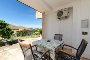 a table and chairs on a patio with a fan at Apartments Kata in Grebaštica