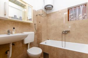 a bathroom with a toilet and a sink and a bath tub at Apartments Kata in Grebaštica +32 photos