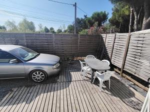 a car parked on a deck with a table and chairs at Camping Les Embruns N2 in Le Grau-dʼAgde