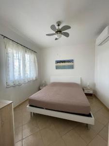 a bedroom with a bed and a ceiling fan at Villetta PEPE nel Salento in Salve