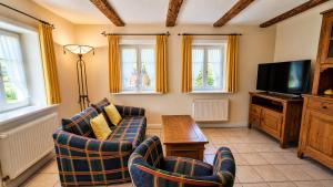 a living room with two chairs and a flat screen tv at Egestorfer Hof in Egestorf