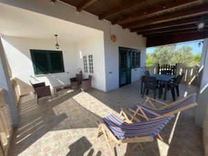 a patio with chairs and a table and a dining room at Villetta PEPE nel Salento in Salve