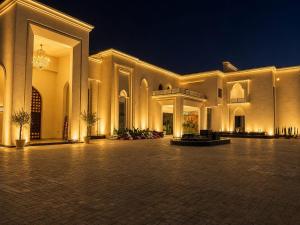 a large building with a courtyard at night at Emerald Resorts and Hotel in Jāmb