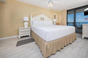 a bedroom with a large bed and a balcony at Phoenix VI 6610 in Orange Beach