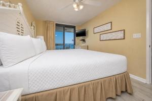 a bedroom with a large white bed and a window at Phoenix VI 6610 in Orange Beach
