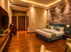 a hotel room with a bed and a television at Emerald Resorts and Hotel in Jāmb +7 photos