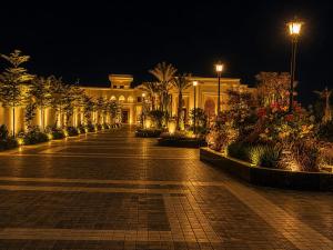 a building at night with a courtyard with flowers at Emerald Resorts and Hotel in Jāmb