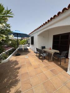 a patio with a table and chairs and an umbrella at Los Porches K28 in Playa del Ingles