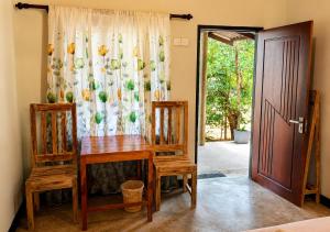 a room with a table and two chairs and a door at Belihuloya Escape and Cafe in Belihuloya