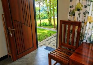 an open door to a room with a wooden chair at Belihuloya Escape and Cafe in Belihuloya