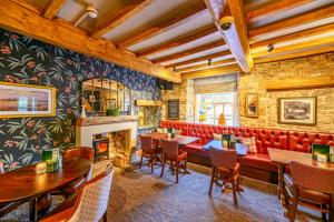 a restaurant with a red couch and a fireplace at The Castle by Innkeeper's Collection in Castleton