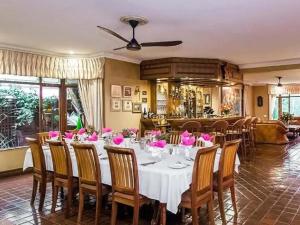 a dining room with a table with pink roses on it at The Woodpecker Inn in Pretoria