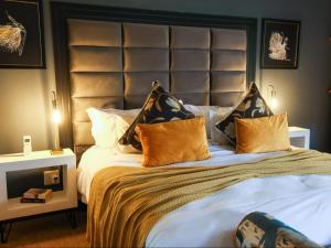 a bedroom with a large bed with a large headboard at The Woodpecker Inn in Pretoria +18 photos