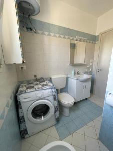 a bathroom with a washing machine and a toilet at Villetta PEPE nel Salento in Salve +6 photos