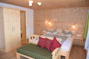 a bedroom with a bed with red pillows on it at Hotel Biobauernhof Hinteraltensberg Wildschönau in Auffach