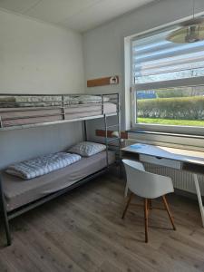 a room with bunk beds and a desk and a chair at Danhostel Tønder in Tønder +24 photos