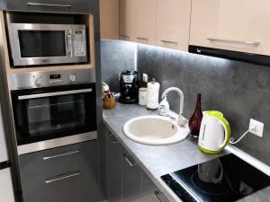 a kitchen with a sink and a microwave at Apartment RELAX, City Centre, Free Wi-Fi, Self Check-In in Ruse