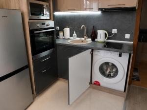 a kitchen with a washing machine and a sink at Apartment RELAX, City Centre, Free Wi-Fi, Self Check-In in Ruse