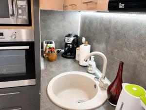a kitchen counter with a sink and a coffee maker at Apartment RELAX, City Centre, Free Wi-Fi, Self Check-In in Ruse