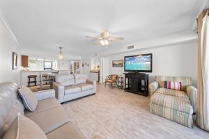 a living room with a couch and chairs and a television at Wind Drift South East 404 in Orange Beach