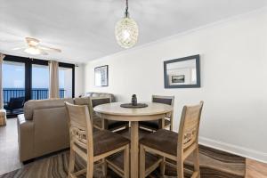 a dining room with a table and chairs and a couch at Wind Drift South East 404 in Orange Beach +37 photos