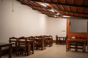a room with tables and chairs and a white wall at Rock Retreat in Kanakapura