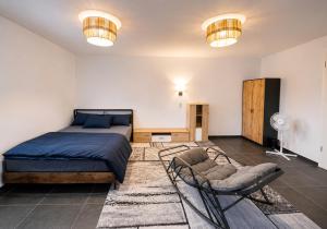 a bedroom with a bed and a chair and lights at Hotelikum zentreal Bequem in Heilbronn