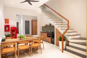a kitchen and dining room with a wooden table and stairs at Dorm Beachside Hotel & Hostel By Haviland in Danang