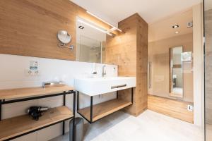a bathroom with a white sink and wooden walls at Genussgut Krispel in Neusetz +39 photos