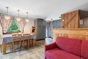 a living room with a table and a red couch at Punta Ceresole 4061 Maison Gerard in Cogne