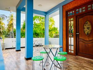 a room with blue columns and a table and stools at Viyona Guest House in Trincomalee