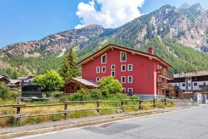 a red building in front of a mountain at Punta Ceresole 4061 Maison Gerard in Cogne
