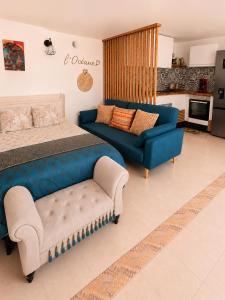 a bedroom with a blue bed and a couch at L'océane in Saint-Maurice-de-Beynost