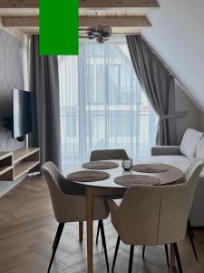 a dining room with a table with chairs and a couch at Białe Wierchy Kościelisko in Witów