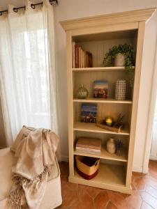 a book shelf with books on it next to a window at Entre Ciels et Lettres in Grignan