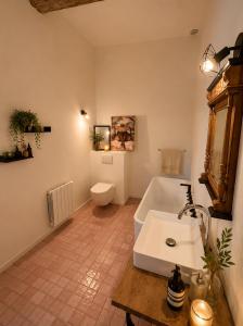 a bathroom with a tub and a toilet and a sink at Entre Ciels et Lettres in Grignan +20 photos