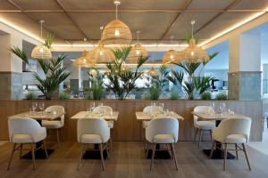 a restaurant with tables and chairs and chandeliers at Alua Linda Mallorca - Newly Renovated 2026 in Can Pastilla