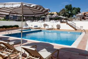 a swimming pool with chairs and an umbrella at Alua Linda Mallorca - Newly Renovated 2026 in Can Pastilla