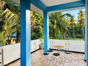 a room with palm trees and a table and stools at Viyona Guest House in Trincomalee